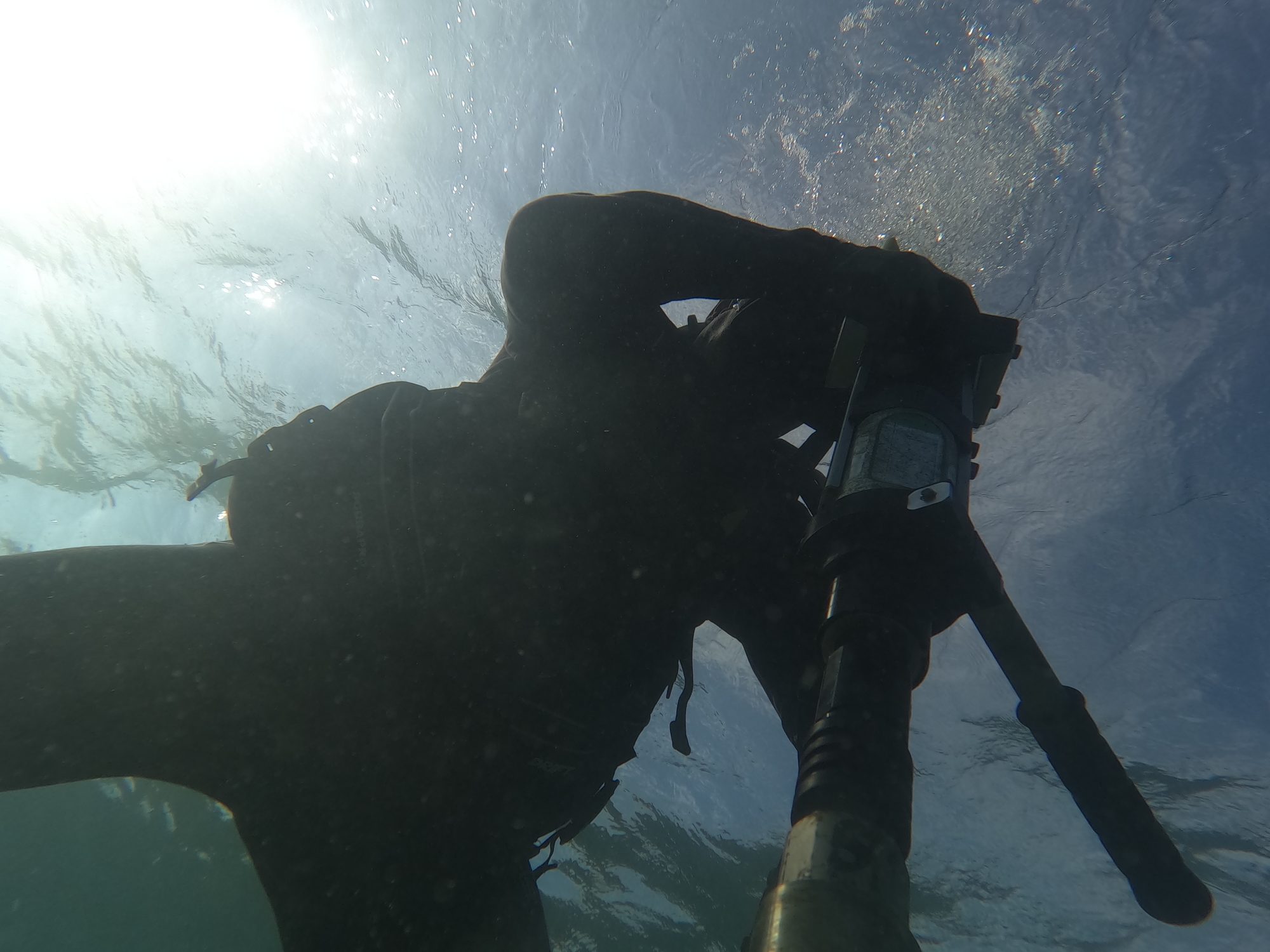 Buzo Kraken instalando anclaje submarino con taladro neumático - vista desde el fondo hacia la superficie
